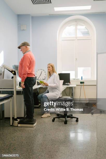 doctor weighting patient - berlin weigh in stock-fotos und bilder