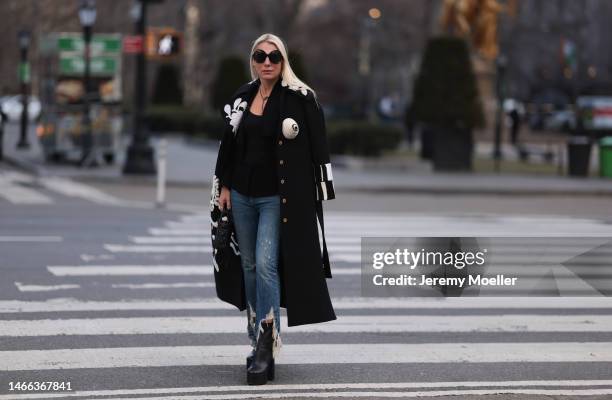 Corina Mihaila Larpin seen wearing Linda Fargo black sunglasses, Schiaparelli black long coat with white ornament print pattern, R13 dark blue...