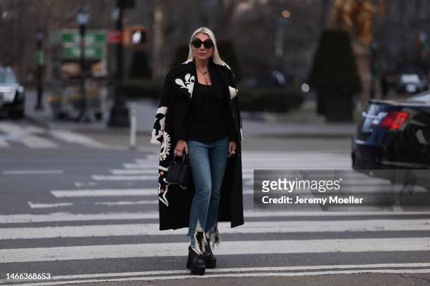 Corina Mihaila Larpin seen wearing Linda Fargo black sunglasses, Schiaparelli black long coat with white ornament print pattern, R13 dark blue...
