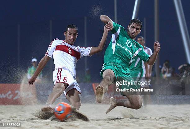Mohamad Mechleb Matar of Lebanon is tackled by Mohammed Barakat of Palestine during the Beach Soccer Men's Bronze Medal Match between Palestine and...