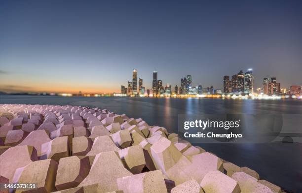 blurred background, qingdao city skyline at night - groyne stock pictures, royalty-free photos & images