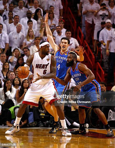 LeBron James of the Miami Heat looks to pass the ball against Nick Collison and James Harden of the Oklahoma City Thunder in Game Three of the 2012...