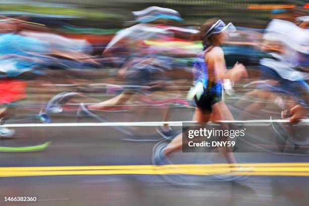 blurred action of marathon runners on city street - maratona imagens e fotografias de stock