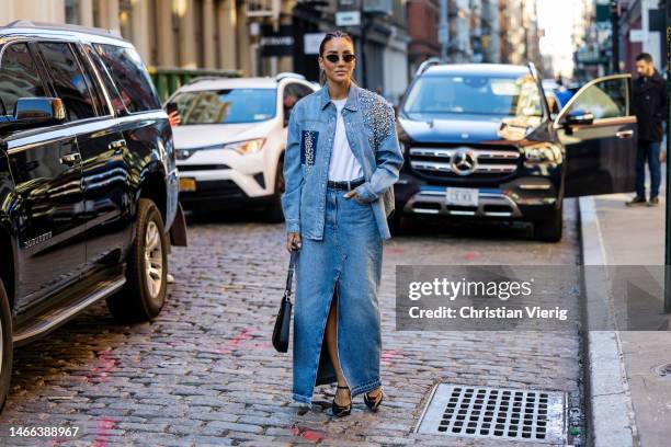 Tamara Kalinic wears denim jacket with rhinestones, denim skirt with slit, Prada bag, pointed heels sunglasses outside Hellessy during New York...