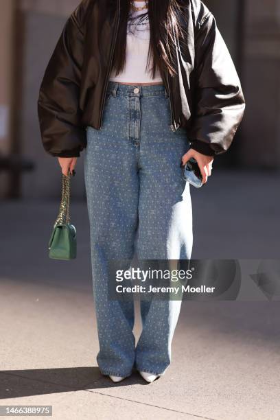 Jennifer Nisan seen wearing Tiffany & Co. Gold graduated link necklace, white printed cropped top, brown oversize leather jacket, Chanel blue logo...