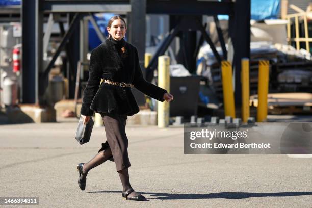 Guest wears gold earrings, a black scarf, a black fluffy jacket, a beige with brown and black leopard print pattern leather belt, a dark brown midi...