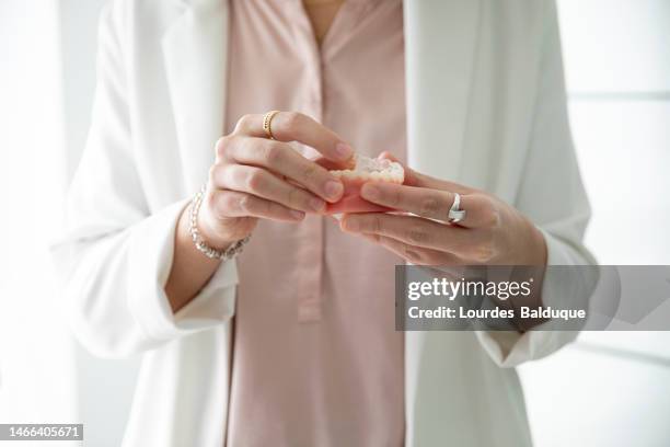 patient using the model as an example of orthodontics - odontología cosmética fotografías e imágenes de stock