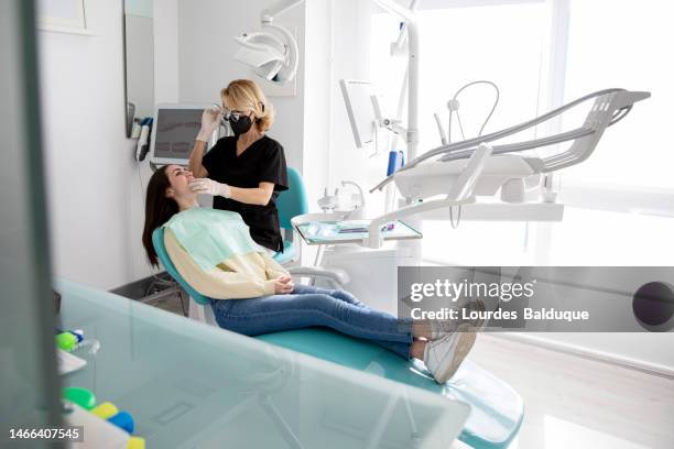 teen girl puts on transparent braces at the dentist - bruxism stock pictures, royalty-free photos & images