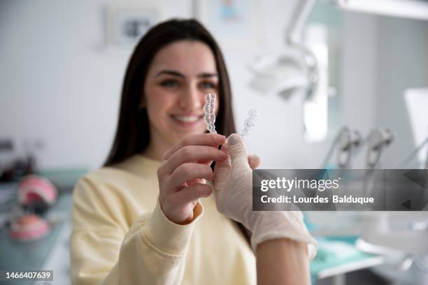 teen girl puts on transparent braces at the dentist - dental occlusion stock pictures, royalty-free photos & images