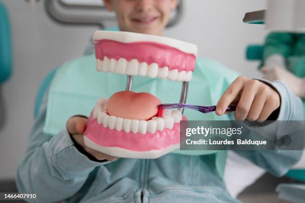 teenager learns to clean teeth at the dentist - alcala de henares stock pictures, royalty-free photos & images