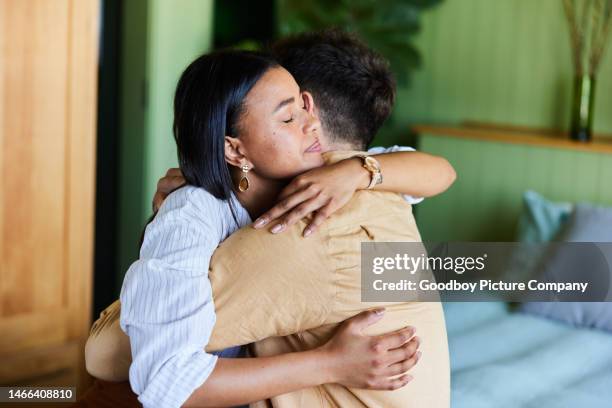 mujer amorosa abrazando a su marido molesto en su habitación en casa - embracing fotografías e imágenes de stock