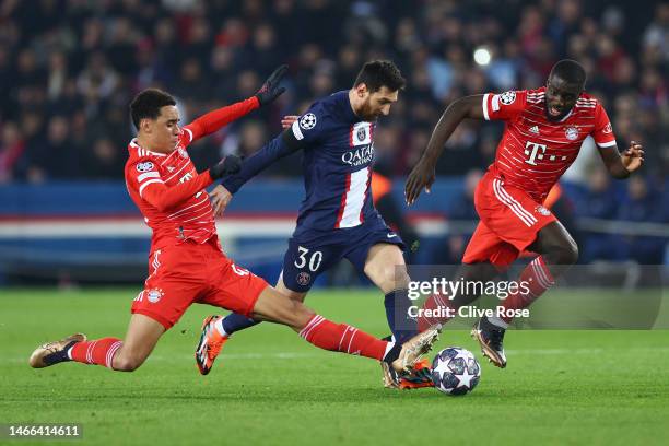 Lionel Messi of Paris Saint-Germain is challenged by Jamal Musiala and is marked by Dayot Upamecano of FC Bayern Munich during the UEFA Champions...