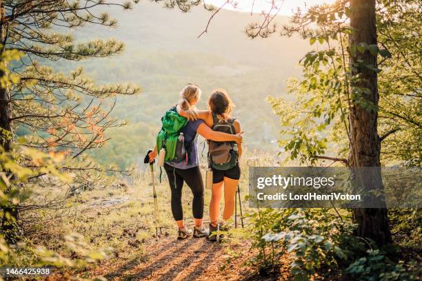 mother and daughter hikers embracing each other - active lifestyle stock pictures, royalty-free photos & images