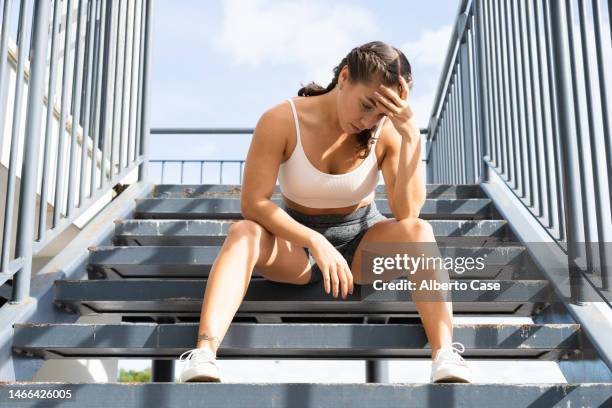 a tired woman after a workout at the gym - beautiful woman and tired stock pictures, royalty-free photos & images