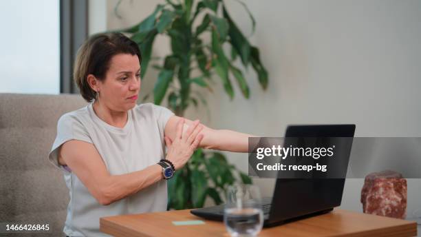 woman applying hormone replacement therapy band on her arm - transdermal stock pictures, royalty-free photos & images