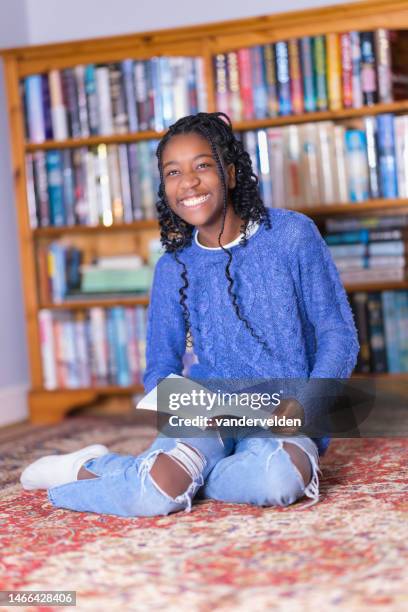 girl with braided hair reading - curled up reading book stock pictures, royalty-free photos & images