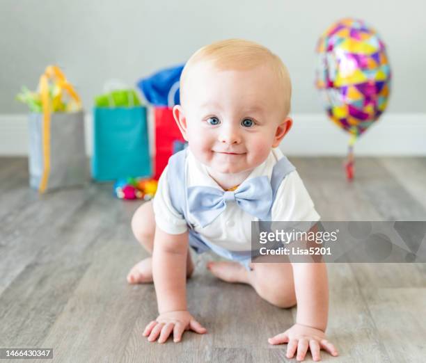 cute 1 year old baby boy celebrating his first birthday with presents and balloon - eerste verjaardag stockfoto's en -beelden