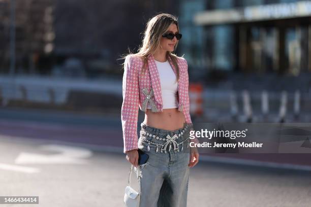 Valentina Ferrer seen wearing Prada shades and a Prada Cleo bag, a patterned cropped blazer, a white shirt, oversized jeans and plateau heels before...