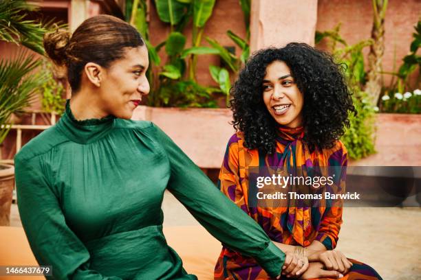 medium shot smiling sisters relaxing on hotel rooftop during vacation - arab family in hotel stock-fotos und bilder