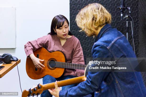 instructor and student during guitar lesson - makiko tanigawa stock-fotos und bilder