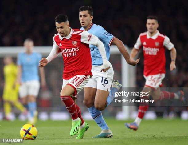 Gabriel Martinelli of Arsenal runs with the ball whilst under pressure from Rodri of Manchester City during the Premier League match between Arsenal...