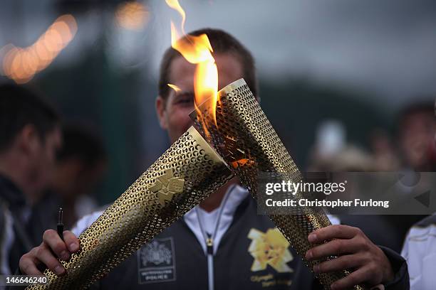 Olympic torches 'Kiss' as The Olympic flame passes to the next torch bearer at Bowness-On-Windermere on June 21, 2012 in Windermere, England. The...
