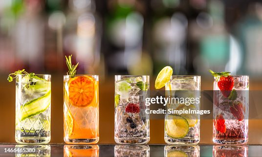 Five gin tonic cocktails in wine glasses on bar counter in pup or restaurant. Five gin tonic cocktails in wine glasses on bar counter in pup or restaurant.