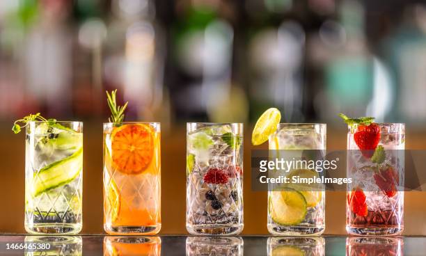 five gin tonic cocktails in wine glasses on bar counter in pup or restaurant. - vodka bildbanksfoton och bilder
