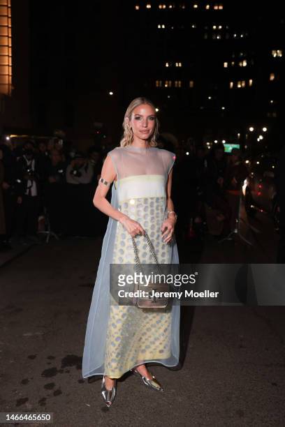 Leonie Hanne seen wearing a full Tory Burch look, long transparent dress with silver dots and silver shiny shoes and a rose and green shiny handbag...