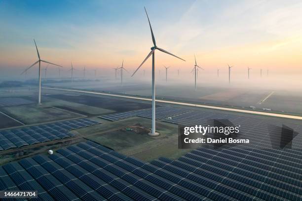 solar energy field and wind turbines seen from the air during sunrise - windmolens stockfoto's en -beelden