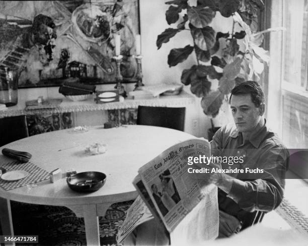 Actor Rock Hudson reads the Los Angeles Times at his house in 1961, Los Angeles, California.