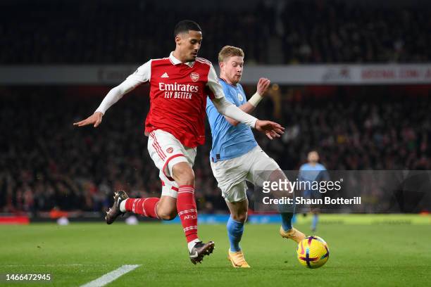 William Saliba of Arsenal runs with the ball whilst under pressure from Kevin De Bruyne of Manchester City during the Premier League match between...