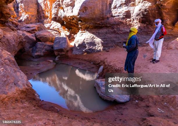 Tuaregs near a waterhole in the desert, Tassili N'Ajjer National Park, Tadrart Rouge, Algeria on December 31, 2022 in Tadrart Rouge, Algeria.