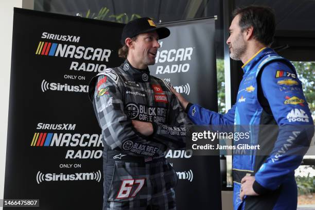 Jimmie Johnson, driver of the Carvana Chevrolet, and Travis Pastrana, driver of the Black Rifle Coffee Toyota, speak during the NASCAR Cup Series...