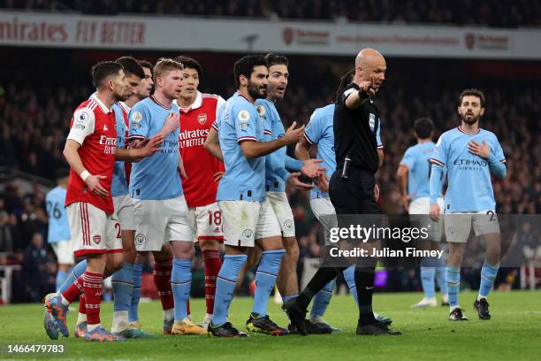 Players of Manchester City and Arsenal protest as Referee Anthony Taylor waits for the VAR Review during the Premier League match between Arsenal FC...