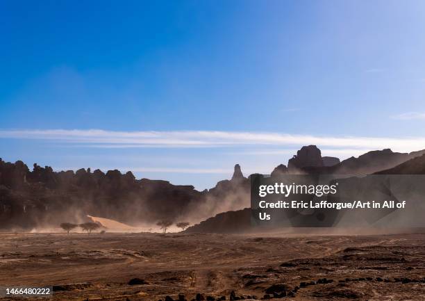 Rocks and sand dunes in windy Sahara desert, Tassili N'Ajjer National Park, Tadrart Rouge, Algeria on December 31, 2022 in Tadrart Rouge, Algeria.