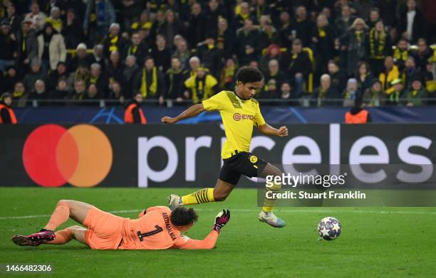 Karim Adeyemi of Borussia Dortmund goes around Kepa Arrizabalaga of Chelsea to score the teams first goal during the UEFA Champions League round of...