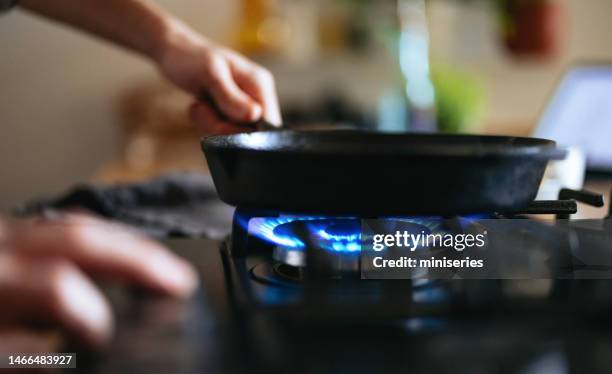 close up photo of manâs hands turning switch knob on gas stove - gasbrander stockfoto's en -beelden