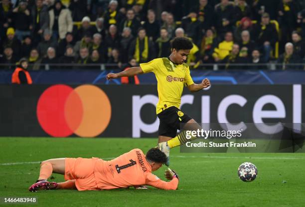 Karim Adeyemi of Borussia Dortmund goes around Kepa Arrizabalaga of Chelsea to score the teams first goal during the UEFA Champions League round of...