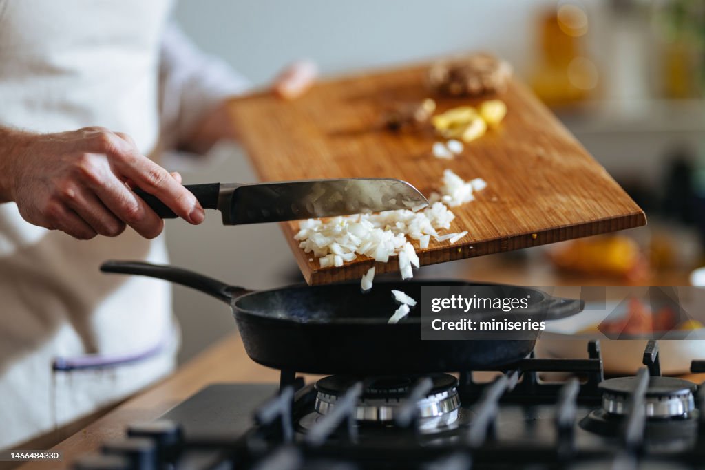 Close Up Photo Of Manâs Hands Putting Chopped Onions In The Pan