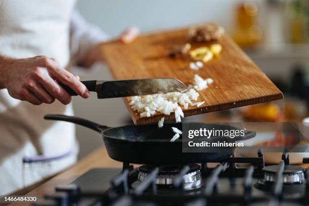 close up photo of manâs hands putting chopped onions in the pan - chef knives stock pictures, royalty-free photos & images