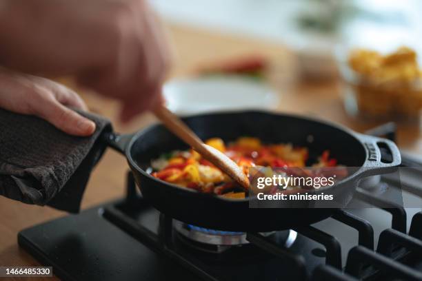 close up photo of manâs hands preparing healthy lunch in the pan at home - stirring stock pictures, royalty-free photos & images