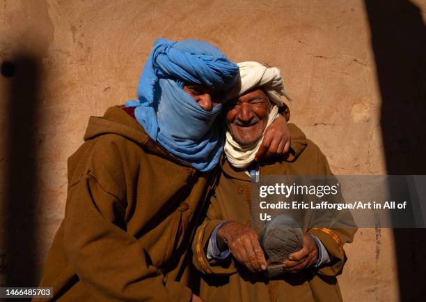 Two men in bournous laughing together in the street, North Africa, Metlili, Algeria on January 5, 2023 in Metlili, Algeria.