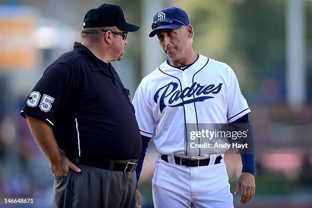 Bud Black of the San Diego Padres discusses a call with umpire Wall Bell at third base against the Texas Rangers during an interleague game at Petco...