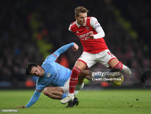 Martin Odegaard of Arsenal wins the ball from Jack Grealish of Man Ciduring the Premier League match between Arsenal FC and Manchester City at...