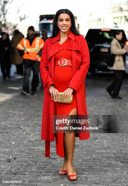 Hannah Bronfman is seen wearing a red Michael Kors coat and dress with a gold bag outside the Michael Kors show during New York Fashion Week F/W 2023...