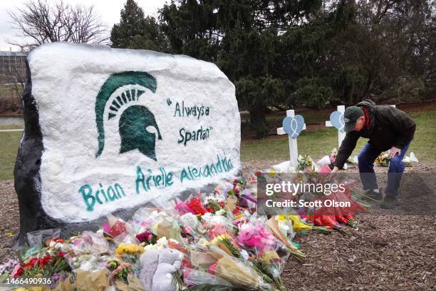 People leave flowers by "The Rock", on the campus of Michigan State University, which is painted as a memorial to those killed by a gunman on...
