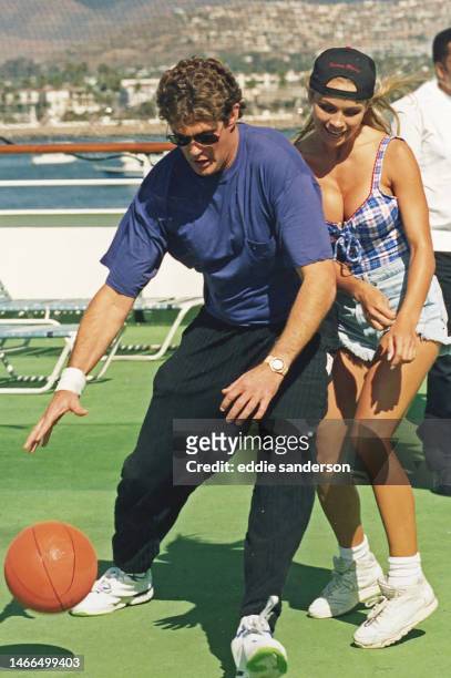 Actress Pamela Anderson and actor David Hasselhoff play basketball on the set of Baywatch in October 1992 on Catalina Island, California.