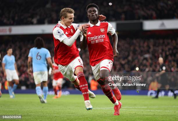 Bukayo Saka of Arsenal celebrates with teammates after scoring the team's first goal from a penalty kick during the Premier League match between...