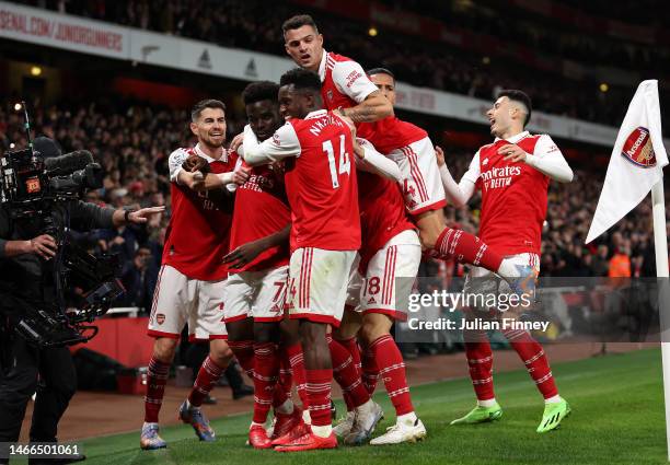 Bukayo Saka of Arsenal celebrates with teammates after scoring the team's first goal from a penalty kick during the Premier League match between...